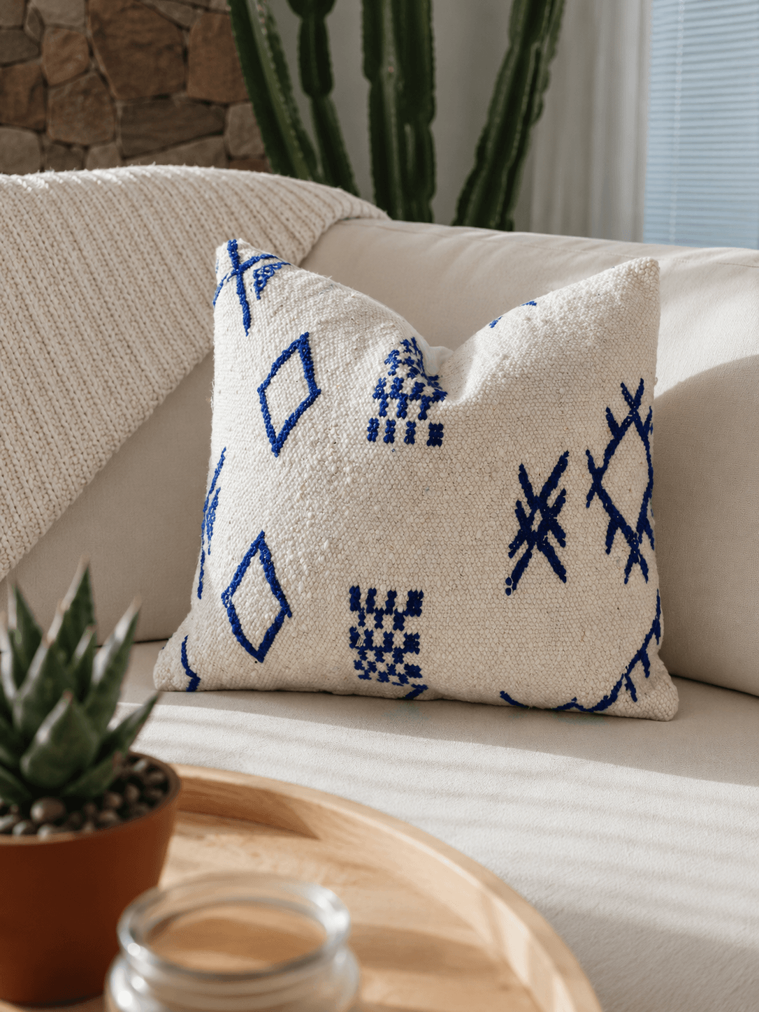 Coussin Hanbel marocain avec motifs géométriques gris, verts et rouges